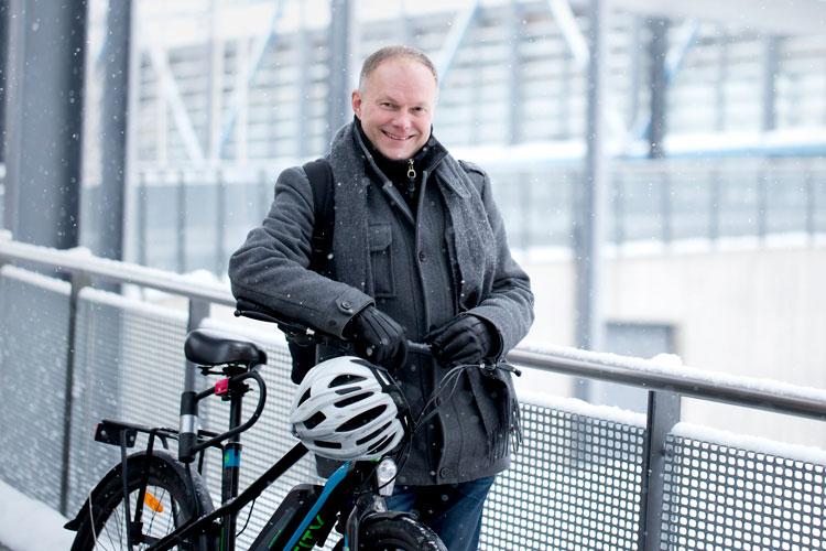 Projektipäällikkö Kari Halinen lumisessa maisemassa pyöränsä vieressä